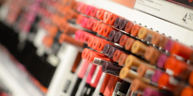 Close-up of diverse lipsticks in a store showcasing various shades and brands for beauty enthusiasts.