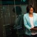 Female IT professional examining data servers in a modern data center setting.