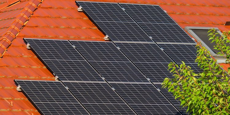 Close-up of solar panels on a red tiled roof in Croatia, highlighting renewable energy.
