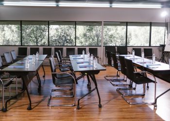 An empty conference room with sleek furniture, ready for a meeting. Bright and professional setting.