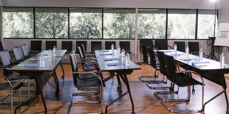 An empty conference room with sleek furniture, ready for a meeting. Bright and professional setting.