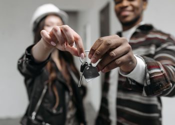 Close-up of a couple joyfully holding keys to their new home, symbolizing new beginnings and home ownership.