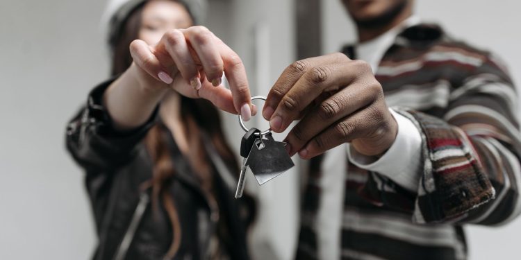 Close-up of a couple joyfully holding keys to their new home, symbolizing new beginnings and home ownership.