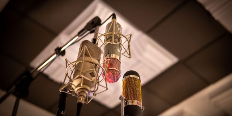 Three condenser microphones arranged for optimal sound capture in a recording studio.
