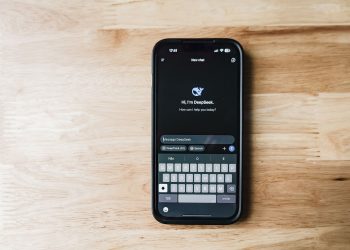 A smartphone on a wooden table showing an AI chatbot interface called DeepSeek.