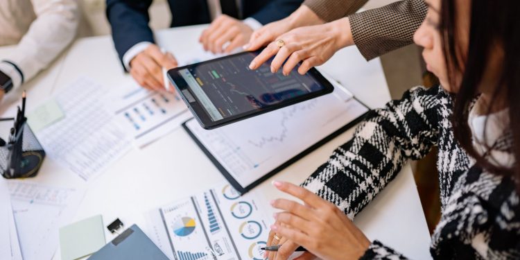 Business professionals reviewing analytics on a tablet during a meeting.