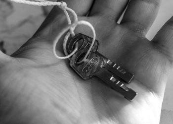 Detailed black and white photo of keys held in a hand, emphasizing texture and detail.