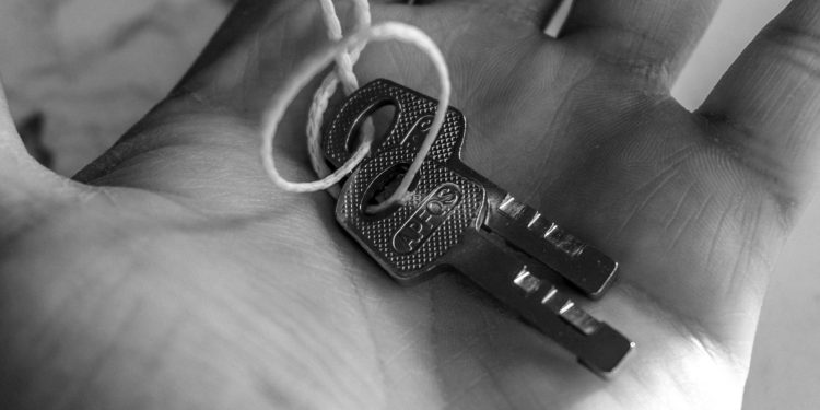 Detailed black and white photo of keys held in a hand, emphasizing texture and detail.