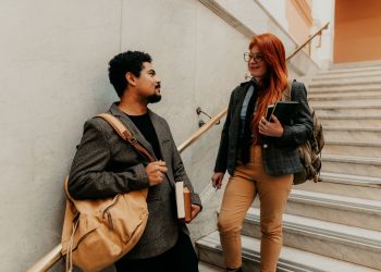 Adult students discussing in a university building on a marble staircase in Buenos Aires.