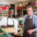 Two male employees organizing products in a cozy grocery store.