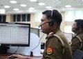 Indian police officers working at a dispatch center, focused and equipped with headsets.
