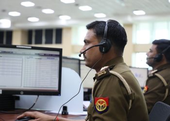 Indian police officers working at a dispatch center, focused and equipped with headsets.