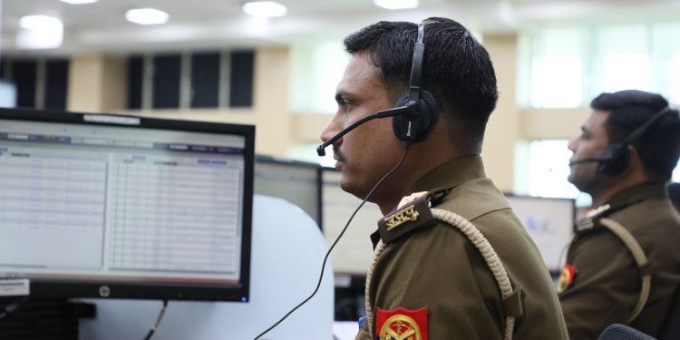 Indian police officers working at a dispatch center, focused and equipped with headsets.