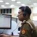Indian police officers working at a dispatch center, focused and equipped with headsets.
