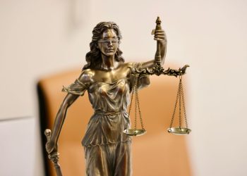 Close-up of Lady Justice statue holding scales, symbolizing justice and fairness.