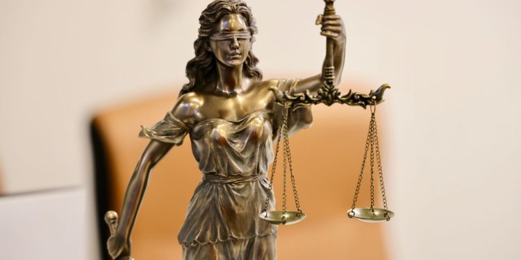 Close-up of Lady Justice statue holding scales, symbolizing justice and fairness.