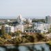 A beautiful day view of Perth city skyline with lush greenery and Swan River.