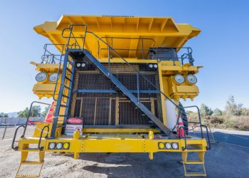 Front view of a large yellow mining truck in Chuquicamata mine, Calama, Chile, on a sunny day.