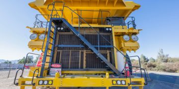 Front view of a large yellow mining truck in Chuquicamata mine, Calama, Chile, on a sunny day.