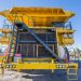 Front view of a large yellow mining truck in Chuquicamata mine, Calama, Chile, on a sunny day.