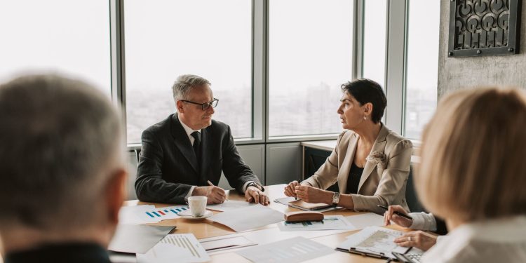 Business professionals engaged in a strategic meeting in a modern office setting with natural light.