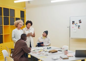 A diverse group of professionals having a collaborative meeting in a modern office space.