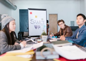 A group of young professionals brainstorming ideas in a startup office setting.
