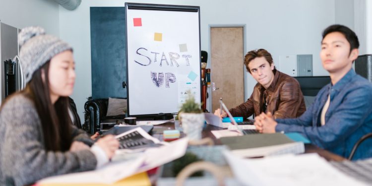 A group of young professionals brainstorming ideas in a startup office setting.