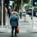 A businessman in a suit crossing the street in a busy urban area during the day.