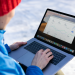 Person working on a laptop analyzing charts in an outdoor setting during winter.