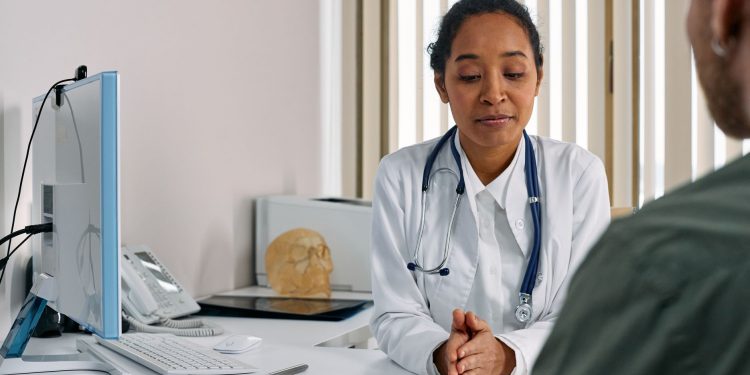 A female doctor consulting a patient in a modern medical office setting.