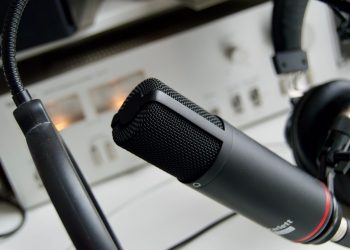 Close-up shot of a microphone in a studio setting, ideal for audio recording.