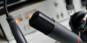 Close-up shot of a microphone in a studio setting, ideal for audio recording.
