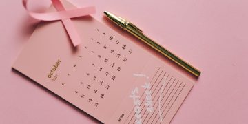 Pink calendar with ribbon and pen for Breast Cancer Awareness in October.