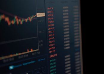 Close-up of a computer screen showing dynamic financial market data and charts, indicating real-time trading updates.