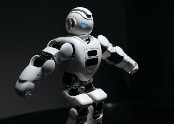 Close-up of a futuristic humanoid robot under dramatic lighting in dark ambiance.