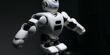 Close-up of a futuristic humanoid robot under dramatic lighting in dark ambiance.