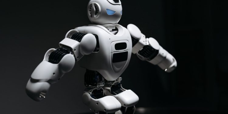 Close-up of a futuristic humanoid robot under dramatic lighting in dark ambiance.
