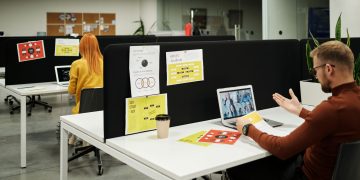 Colleagues working and collaborating virtually at a stylish modern office workspace.
