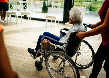 A caregiver assists a senior adult in a wheelchair at a nursing home in Prague, Czech Republic.
