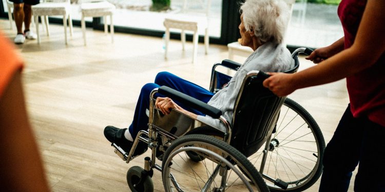 A caregiver assists a senior adult in a wheelchair at a nursing home in Prague, Czech Republic.