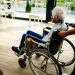 A caregiver assists a senior adult in a wheelchair at a nursing home in Prague, Czech Republic.