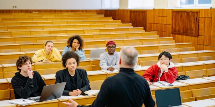 Professor teaching a diverse group of students in a university lecture hall.