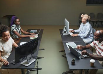 Diverse call center team collaborating in a modern office setting.