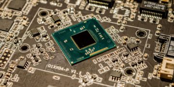 Detailed view of a microchip on a printed circuit board, showcasing electronic components.