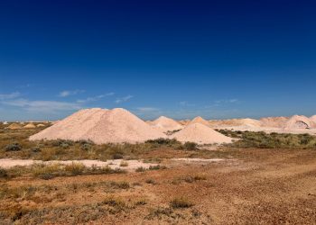 Scenic view of Australian desert showcasing mine dumps under clear blue sky.