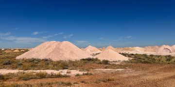 Scenic view of Australian desert showcasing mine dumps under clear blue sky.