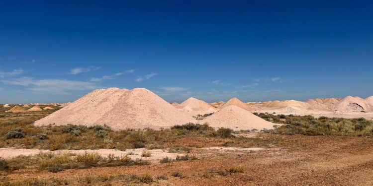 Scenic view of Australian desert showcasing mine dumps under clear blue sky.