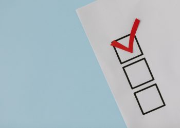 A simple white paper checklist with one red checkmark, ideal for concepts like completion or approval.