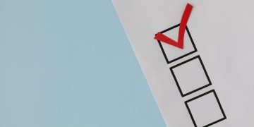 A simple white paper checklist with one red checkmark, ideal for concepts like completion or approval.